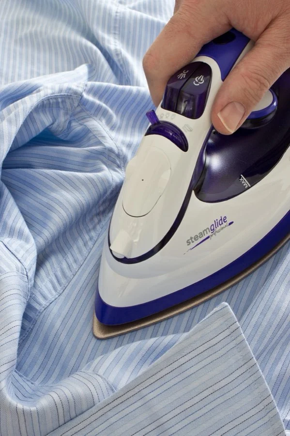 A shirt being pressed with a steam iron